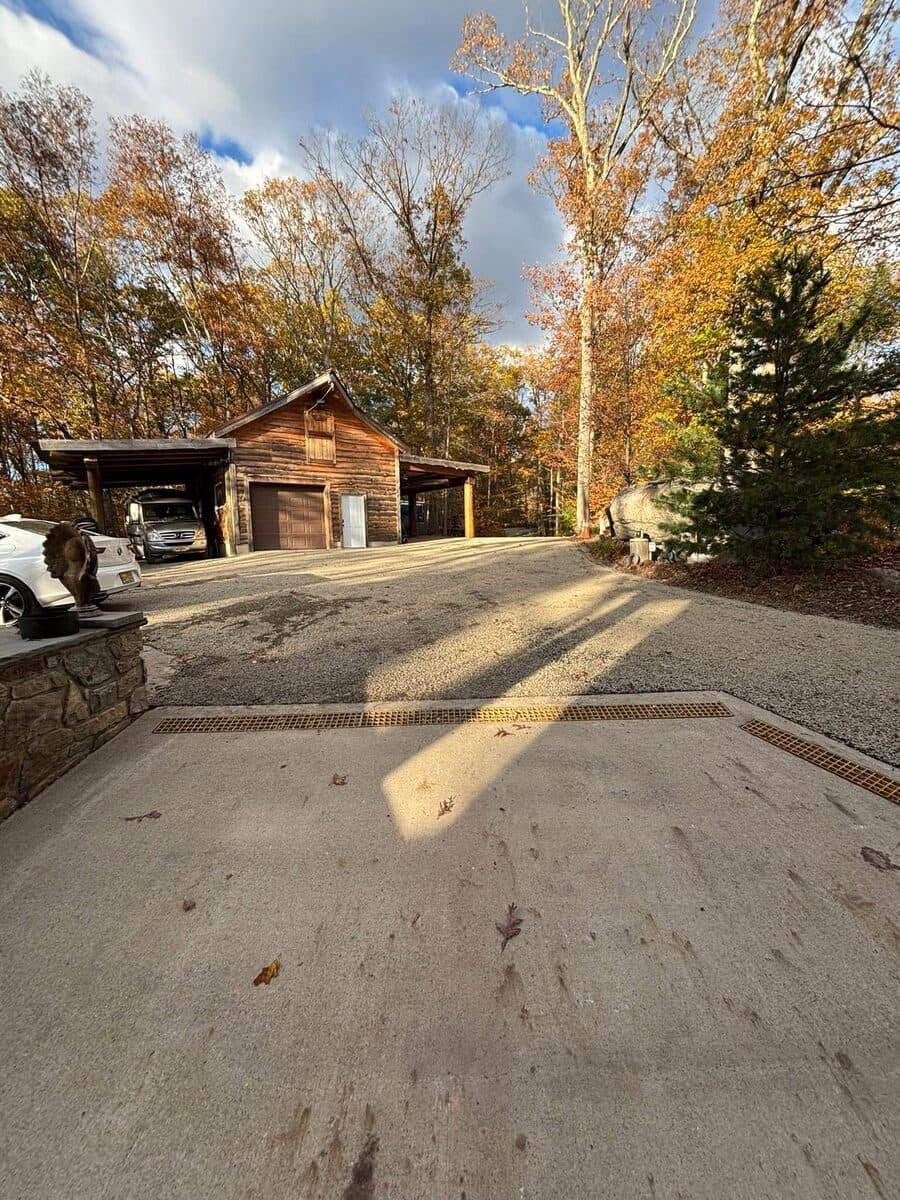 Concrete driveway with a new trench drain installed in front of a garage